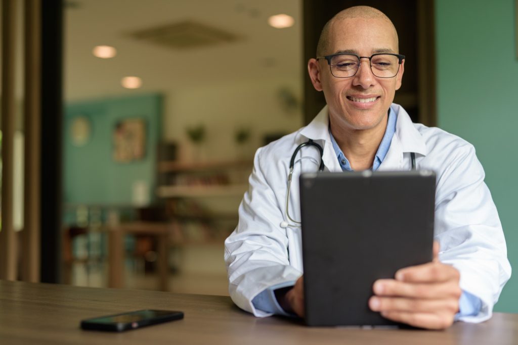 Doctor Sitting in Clinic training on Tablet Computer