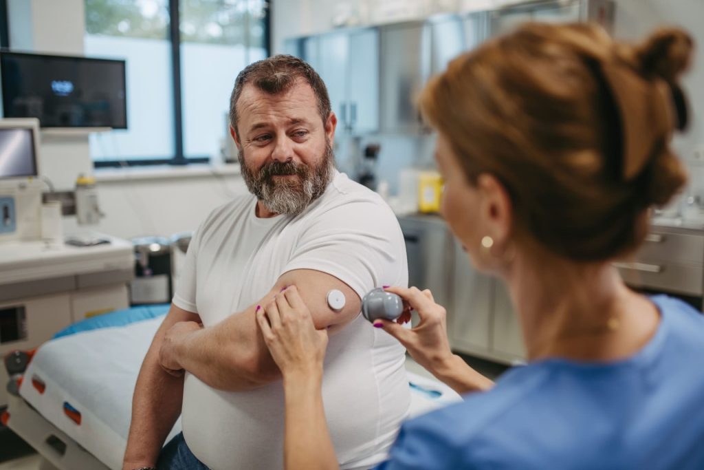 doctor applying continuous glucose monitor
